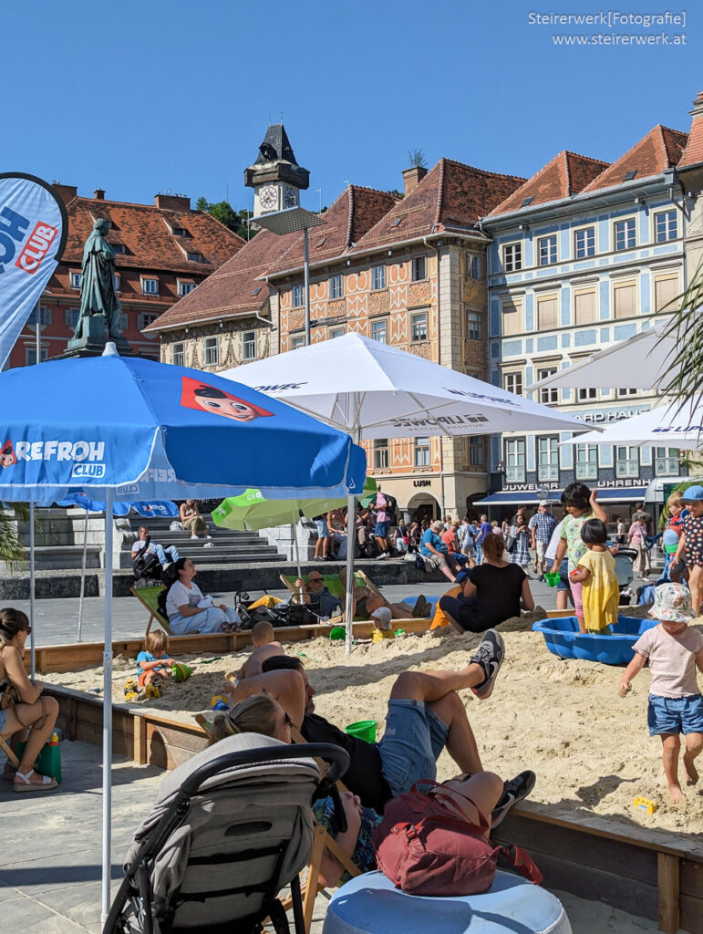 Kinder spielen im Sandkasten am Hauptplatz